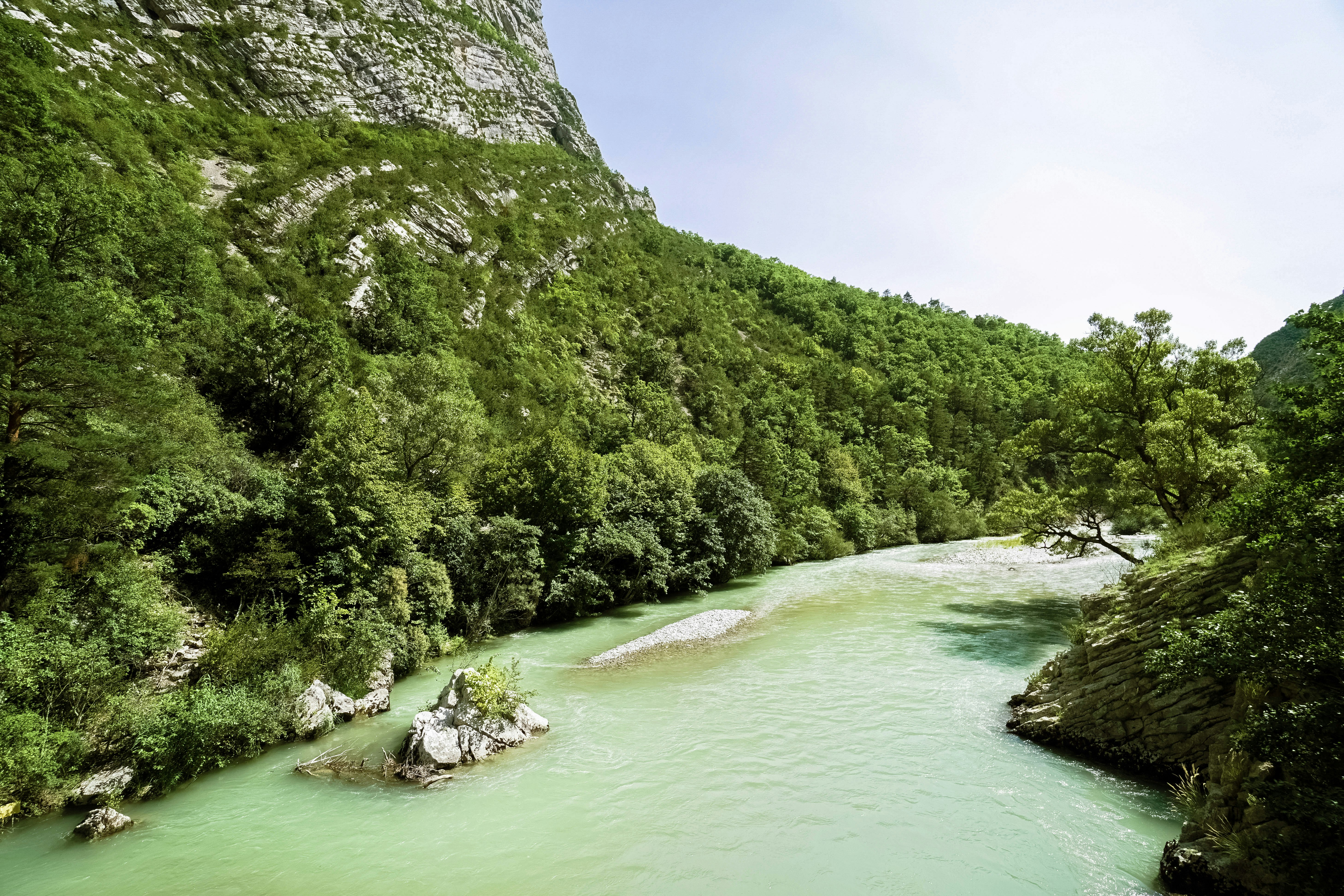 green mountain beside body of water during daytime